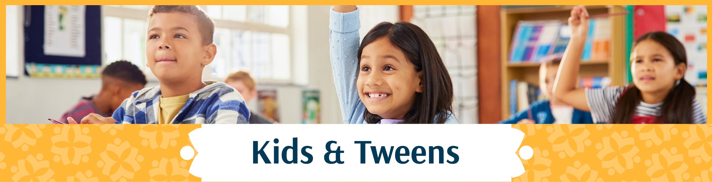 Kids and Tweens header image showing a group of students smiling and raising their hands in what appears to be a classroom