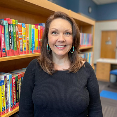 Christy Taylor-Pruitt children's librarian standing in front of a bookcase