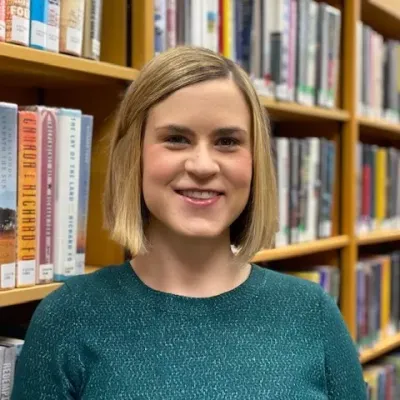 Sara Hodgson head of youth services standing in front of a bookcase